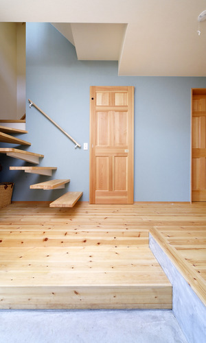 壁から突き出た階段とアクセントの壁紙が、訪れる人の目を引きつける玄関ホール