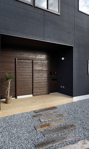 庇代わりに玄関を建物からセットバックさせた、引き戸が似合う外観