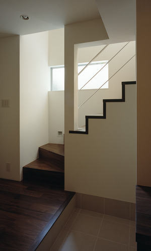 白とウォールナットカラーで統一した、シャープにまとめた玄関