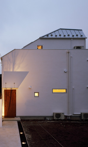 閑静な住宅街に静かに建つ、外観の窓を極力抑えたシンプルな白い家