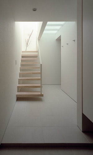 無駄のないデザインでまとめた、壁から出る片持ちの階段が美しい玄関ホール