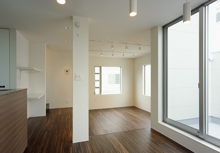 個性的なフローリングが魅力的な、大きめの窓がたくさんあるリビングダイニング