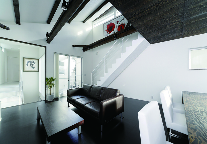 芸術的センスのよい絵画と書が、白黒でまとめたシャープな空間をさらに引き締めるリビング・ダイニング