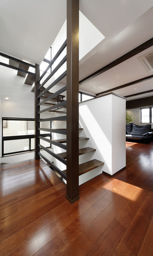 片側の壁面をスポーク上にした、躍動感溢れる階段