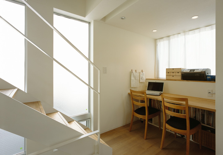 窓を設けた日当たりの良い広めの通路を、コンパクトなワークスペースに