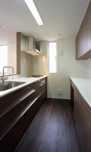 収納とキッチンの色合いをまとめ、ごちゃつきがちなキッチンを美しく見せる