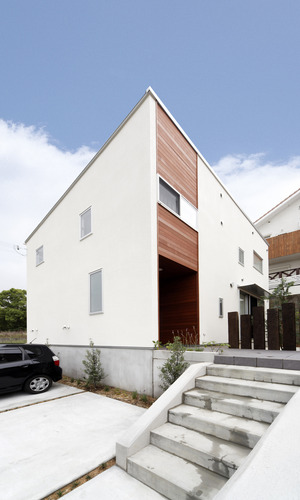 幅のある階段と、枕木をオブジェのように配置した壁が印象的な玄関アプローチ