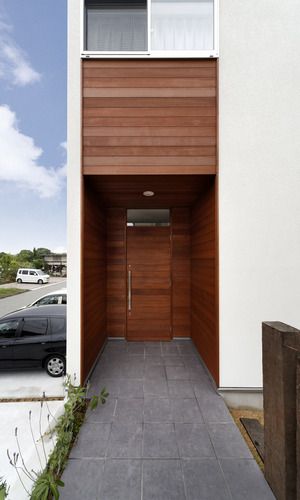 庇代わりに外壁からセットバックさせて玄関ドアを作った、木目の美しい玄関