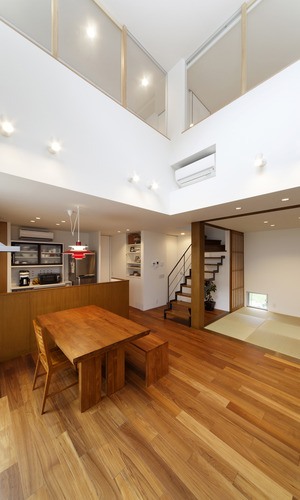 吹き抜けに面してガラス窓を設置した、家族間のつながりが感じられるリビング