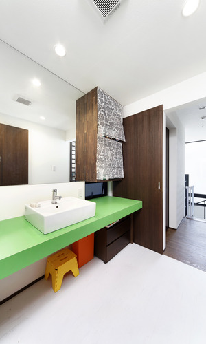 差し色となるビビットカラーが洗面天板がキュートな、シンプルにまとめた洗面所