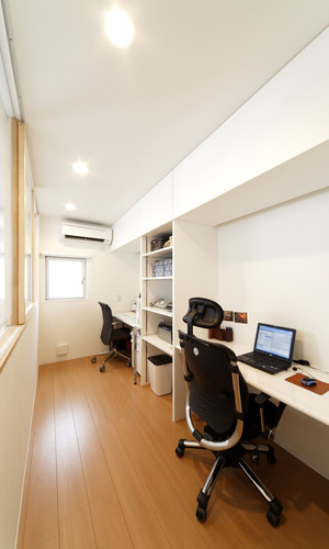 吹き抜けから見えるガラス窓の先に、家族を感じつつ作業できる書斎