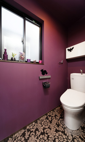 マゼンダカラーの壁と花柄の床が、ノスタルジックなトイレ