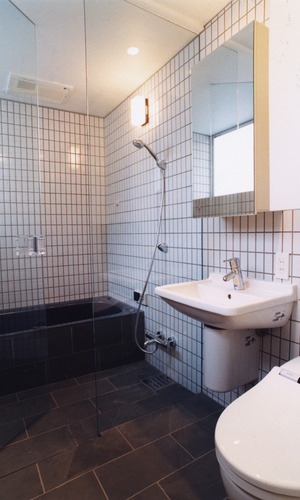 縦長の黒いタイルと目地をグレーにした白タイル使いが、海外のホテルのような浴室