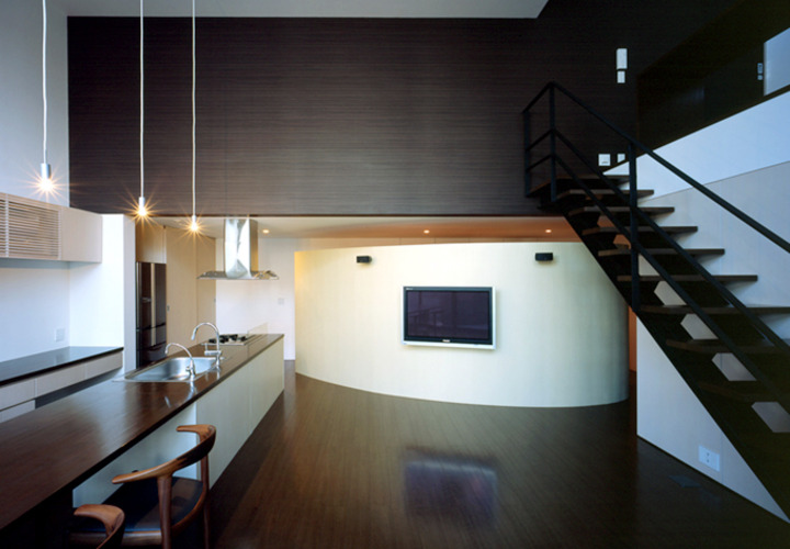 吹き抜けた空間に、湾曲した壁と階段が印象的