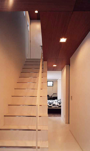 白を基調としながらも天井に使用した木が、あたたかみをプラスした階段周り