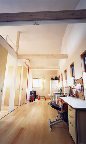 個室と廊下を兼ねた、小窓からの光が眩い天井高のあるワークスペース