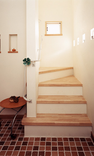 テラコッタを敷き詰めた床と、手すりにチョコンとついた四つ葉のクローバーがキュートな玄関ホール