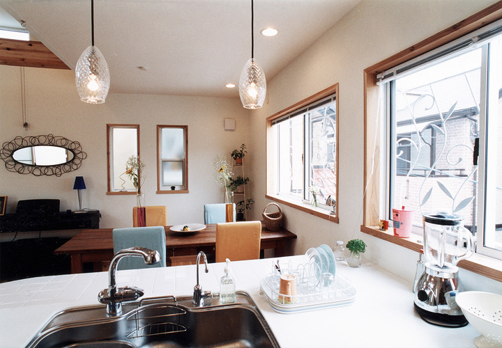 ふんわりとした優しい印象を与える白いアイアン窓格子が、キッチンから見える