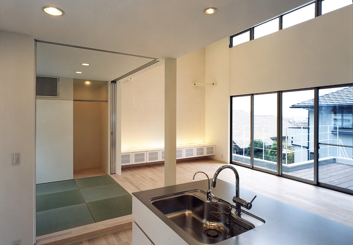 天井高のある吹き抜け空間・光で満ちた全面窓の先には、テラスまでもが室内のように見える