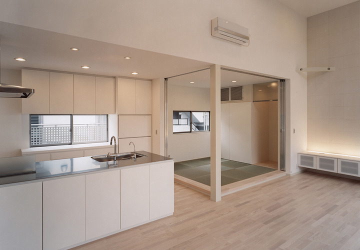 取っ手のないシンプルなキッチン収納が、違和感なく和室へとつながる