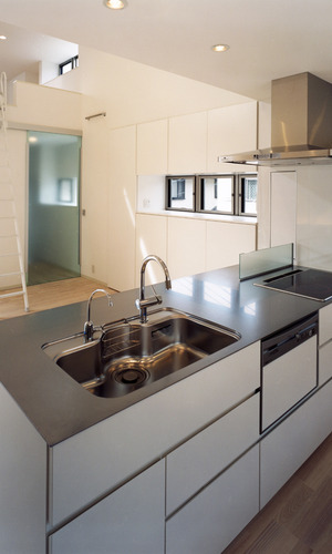 ステンレス一枚板でできた天板が目を引く、奥行きがある超シンプルなキッチン