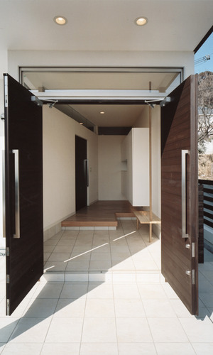 観音開きに開く玄関ドアと、縁側のように癒される広さのある玄関ホール