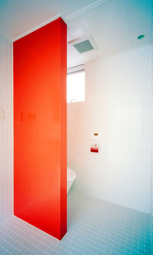 インパクトのある朱い壁が特徴の水まわり