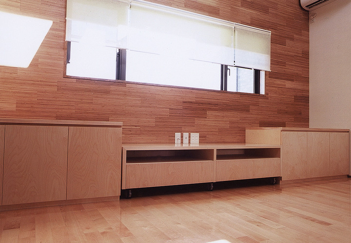 壁面に使用したフローリングのようなビジュアルが、動きのある空間作りに一役買っているリビング