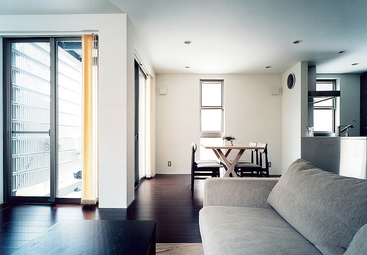 白い壁に焦げ茶色のフローリングが、光を芸術的に反射させるＬＤＫ