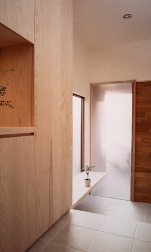 引き戸の玄関ドア横をフロストのフィックス壁にし、柔らかな光が入る玄関