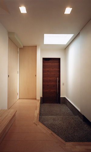 玄関ドアを開けると、トップライトからのみの光が優しくフロアを包み込む玄関ホール