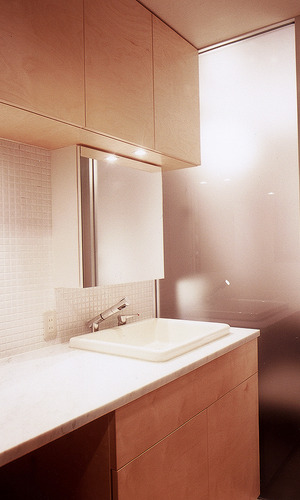 埋込み式コンパクト洗面器と、さまざまなテクスチャーのある素材を取り入れた洗面所