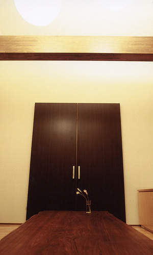 白い壁にどっしりと存在感のある黒い引き戸