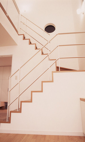 丸窓が似合う、シンプルなラインで構成された美しい階段