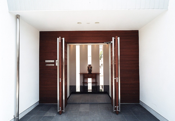 高級アジアンリゾートホテルのような、ファサードからセットバックした観音開きに開く玄関