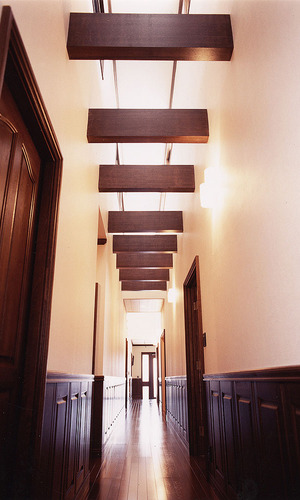 吹き抜け空間に梁をデザインに盛り込んだ、腰壁のある奥行きのある廊下