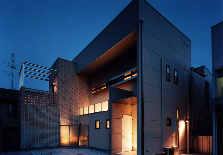 外壁の一部をテラコッタを使用した、隠れ家バーのようなデザイン性の高い夜の外観