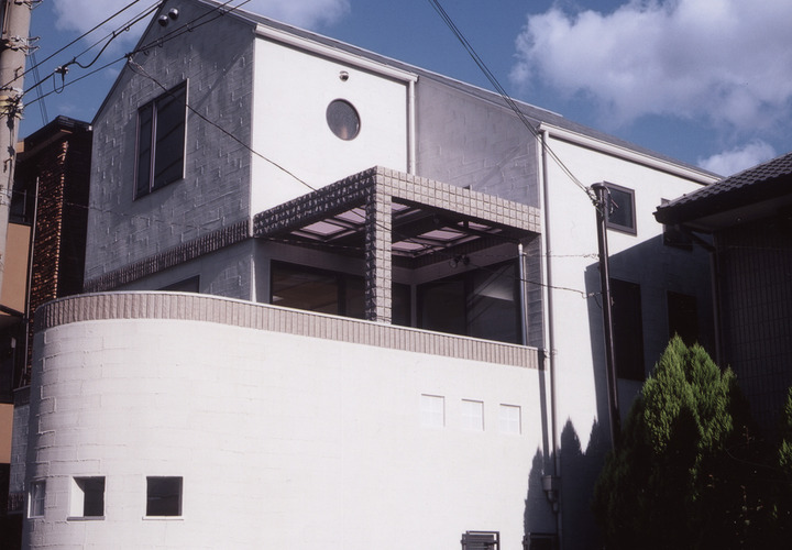 小窓使いとタイルの使い方がかわいらしい、白を基調とした外観