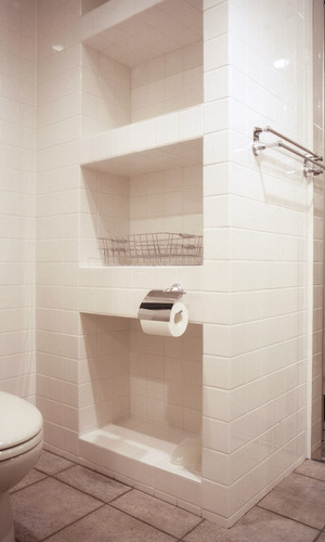 床タイルと白い壁面タイルをバスルームと揃えた、海外住宅のような空間