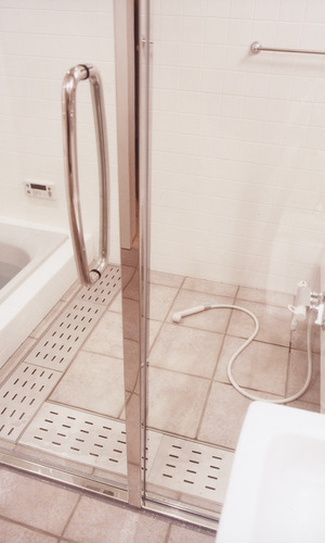 水気を切りやすいように排水部分を多めにした、ガラス扉でスッキリとまとめた在来浴室