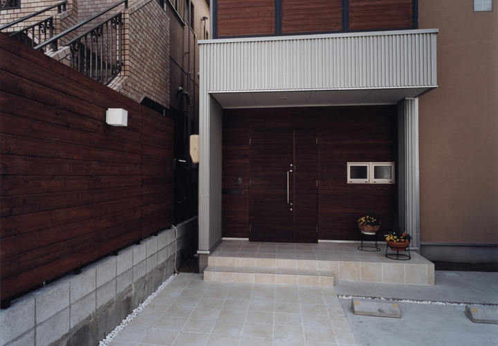 隣地とのブロック塀を活かして作った、高さのあるシックな木塀