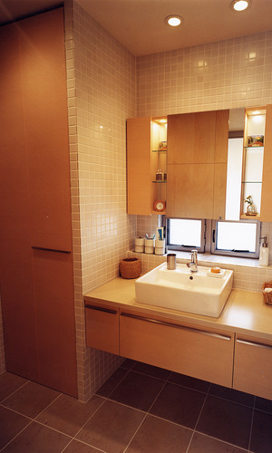 床壁にタイルを使用した、ぬくもりを感じる木を多く使った洗面所