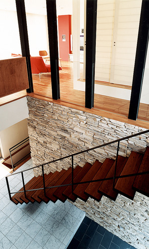 スチール製の階段が飛び出す、立体感のある人造石貼の壁