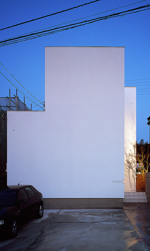 強い日差しと交通量の多い道路を避けるために、機能とデザインを兼ねた「壁」のある外観