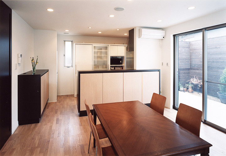 アンティークなダイニングテーブルが、シンプルでクールな空間にマッチするダイニングキッチン