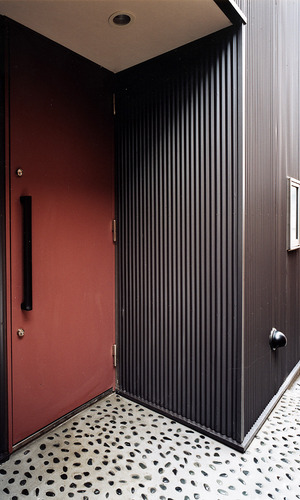 手の込んだコンクリートに石を埋め込む工法が目を引く、玄関アプローチ