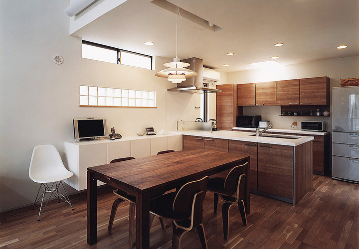 ウォールナットカラーで統一されたダイニングキッチンに、イームズのDCW エバンスチェアが居心地よく佇む