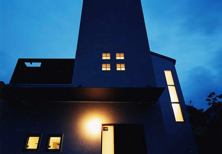 小さな窓から温かい光がそっと灯される、闇に静かに佇む夜の外観