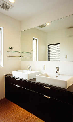 横長に大きな一枚鏡と洗面ボールを２つ設置した、２世帯住宅でも混雑がない広い洗面所