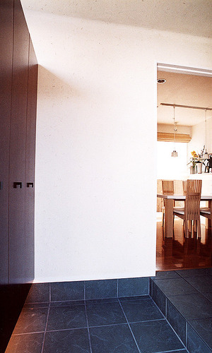 石目調のタイルで玄関・廊下までつなげた、モダンでシックな玄関ホール